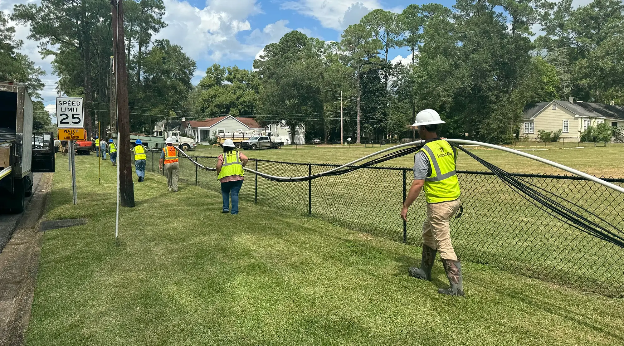 Southeast Gas crew installing natural gas pipeline in residential neighborhood.
