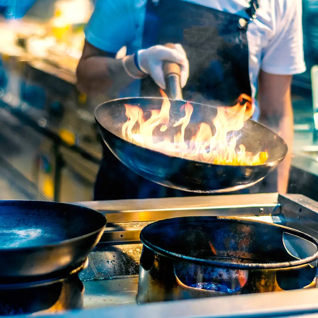 commercial chef cooking on a gas stove