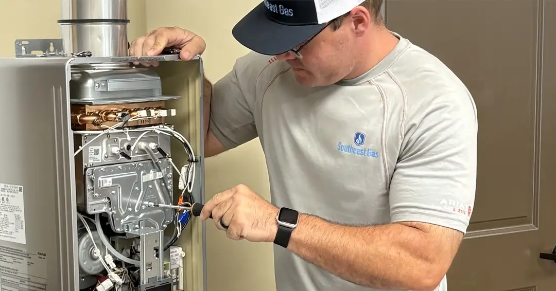 Male technician working on a gas water heater