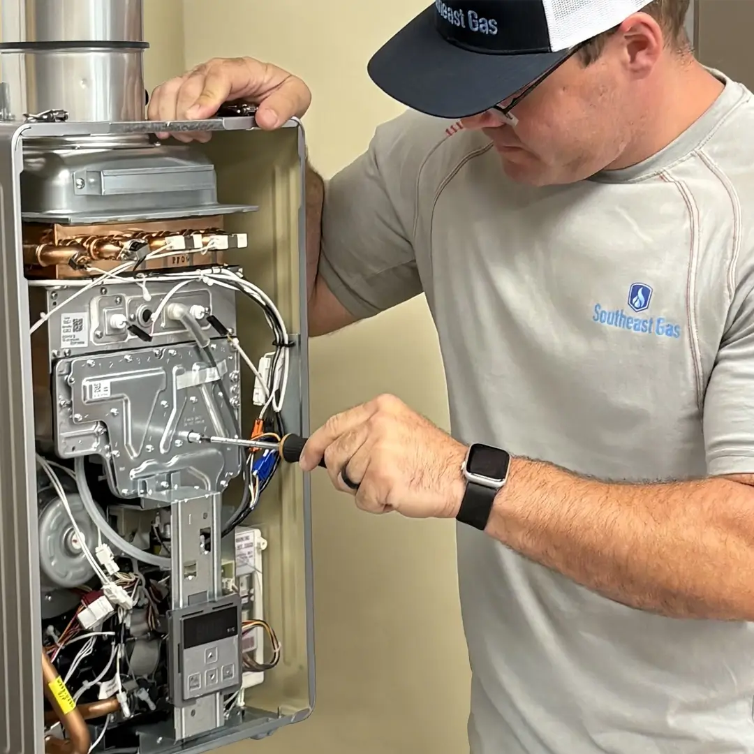 Male technician working on a gas water heater